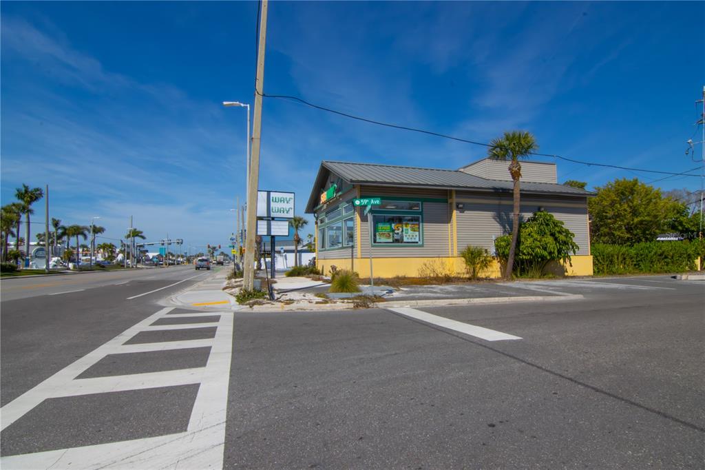 A Subway restaurant building sits on a corner lot next to a road and crosswalk — 5901 GULF BOULEVARD, ST PETE BEACH, FL