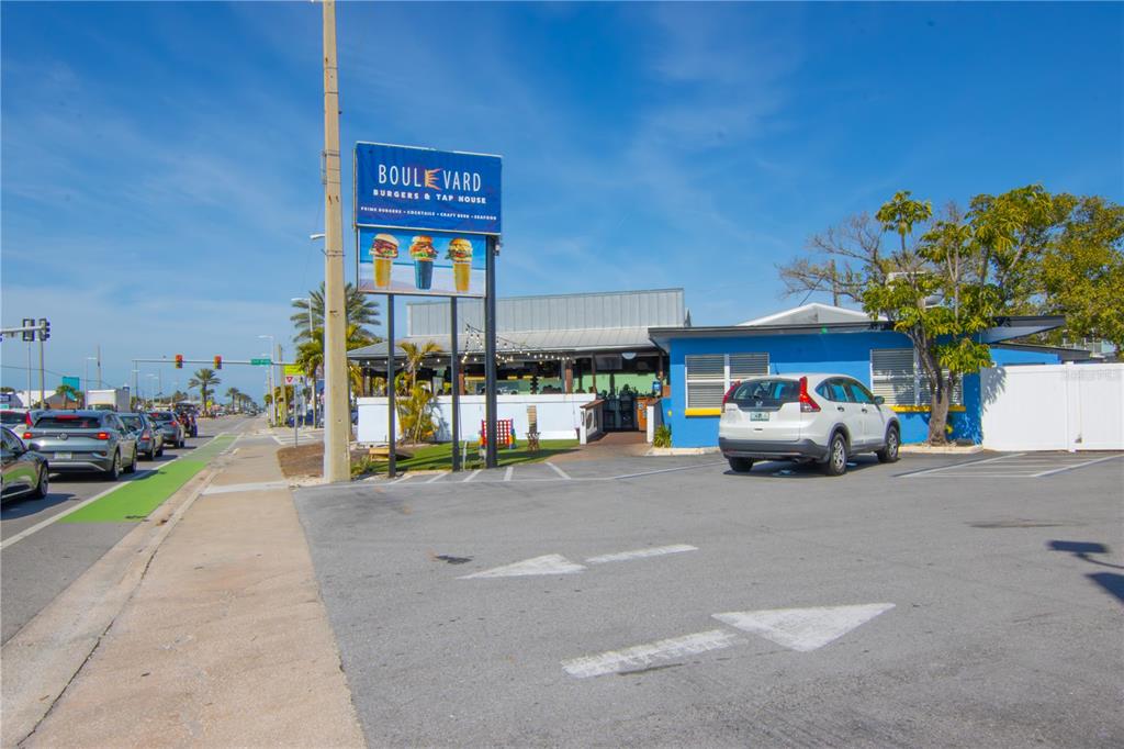 A blue restaurant building with a parking lot and a tall sign stands outdoors — 5901 GULF BOULEVARD, ST PETE BEACH, FL