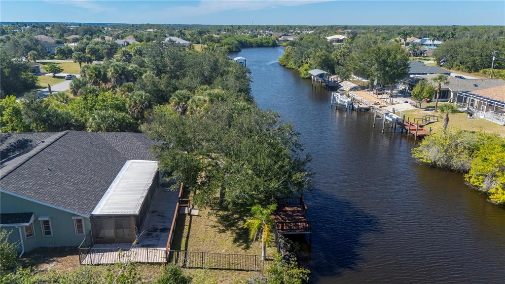 An aerial view of a waterfront house with a backyard deck and private boat dock — 17356 GULFSPRAY CIRCLE, PORT CHARLOTTE, FL