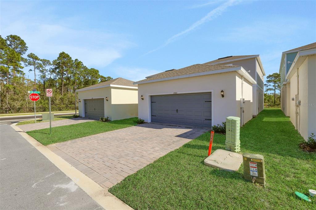 An exterior view of two suburban houses with gray garage doors and paved driveways — 13011 TRANQUIL WATER ALLEY, WINTER GARDEN, FL