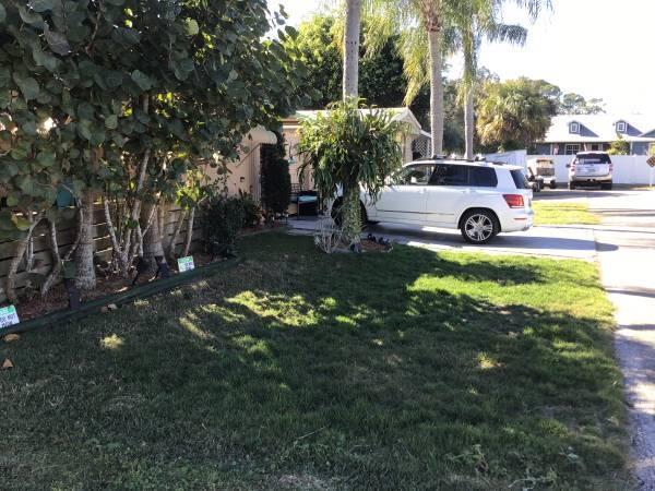 A white SUV is parked in the driveway of a house with a grassy lawn — 1785 SW Diana Terrace, Stuart FL 34997, STUART, FL