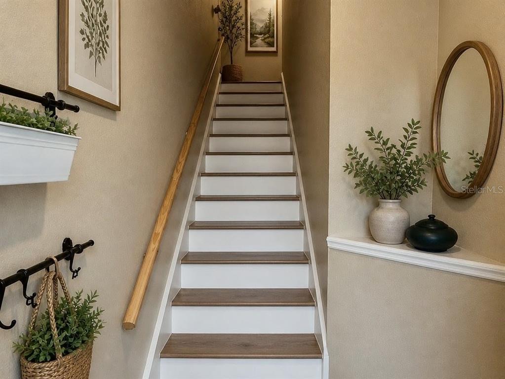 A staircase with white risers and wood-look treads leads upward between two beige walls — 4316 S KIRKMAN ROAD UNIT 1614, ORLANDO, FL