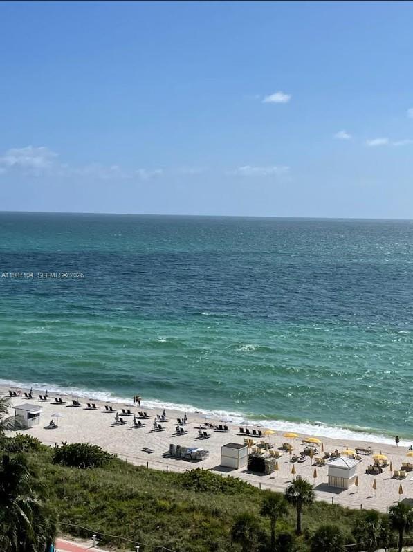 An elevated view of a sandy beach with lounge chairs, umbrellas, and the ocean — 6061 Collins Ave # 12D, Miami Beach FL 33140, MIAMI BEACH, FL
