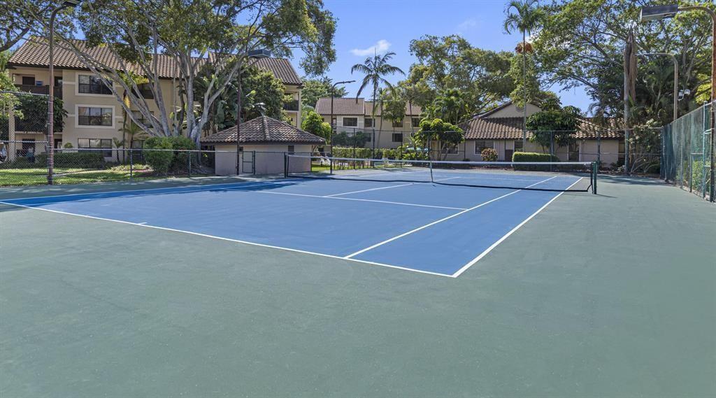 A blue and green tennis court is surrounded by apartment buildings and trees — 4341 W Mcnab Road # 10, Pompano Beach FL 33069, POMPANO BEACH, FL