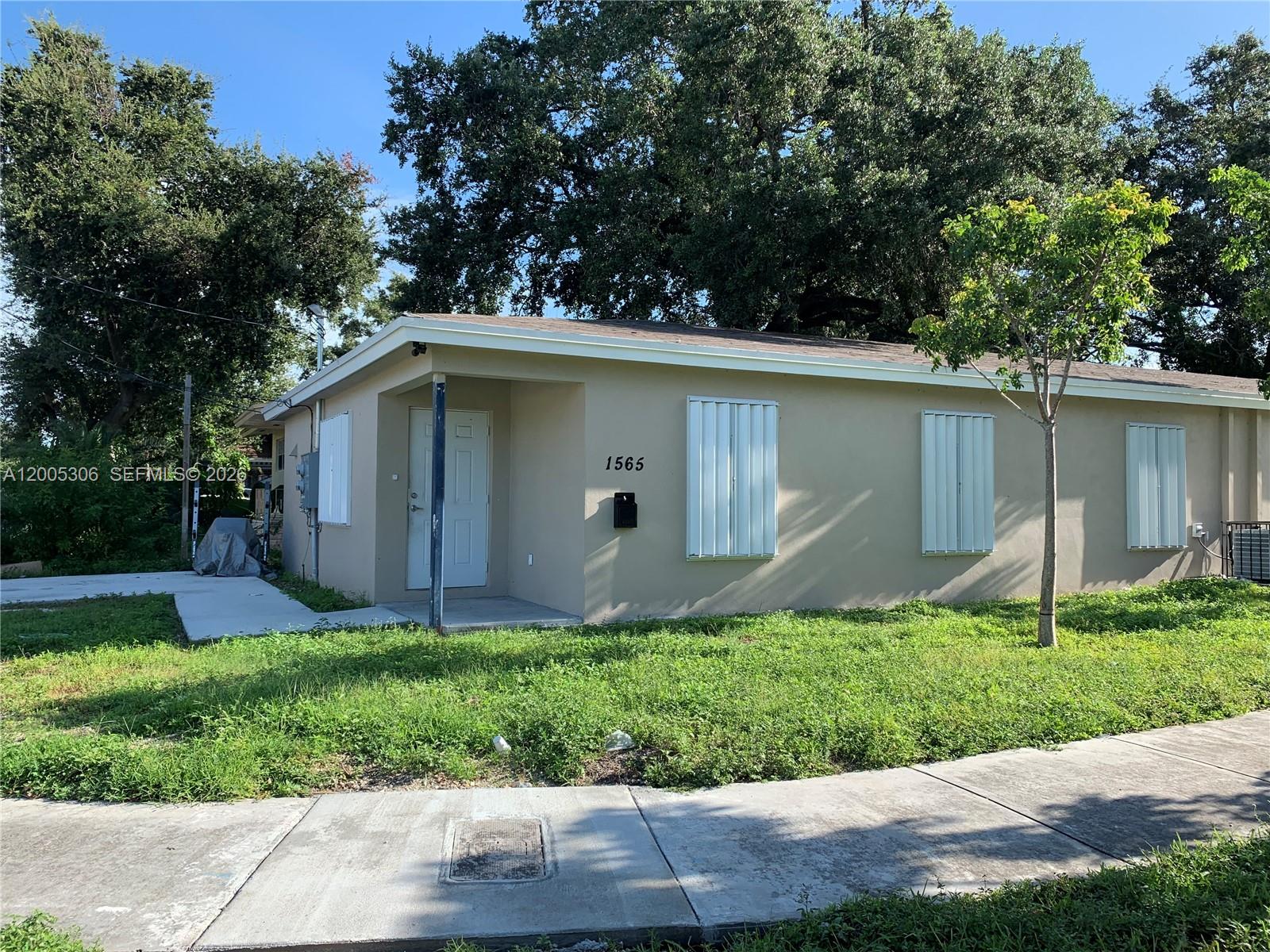 A kitchen with granite countertops and white cabinets opens into a tiled living area — 1565 NW 47th St # 1, Miami FL 33142, MIAMI, FL