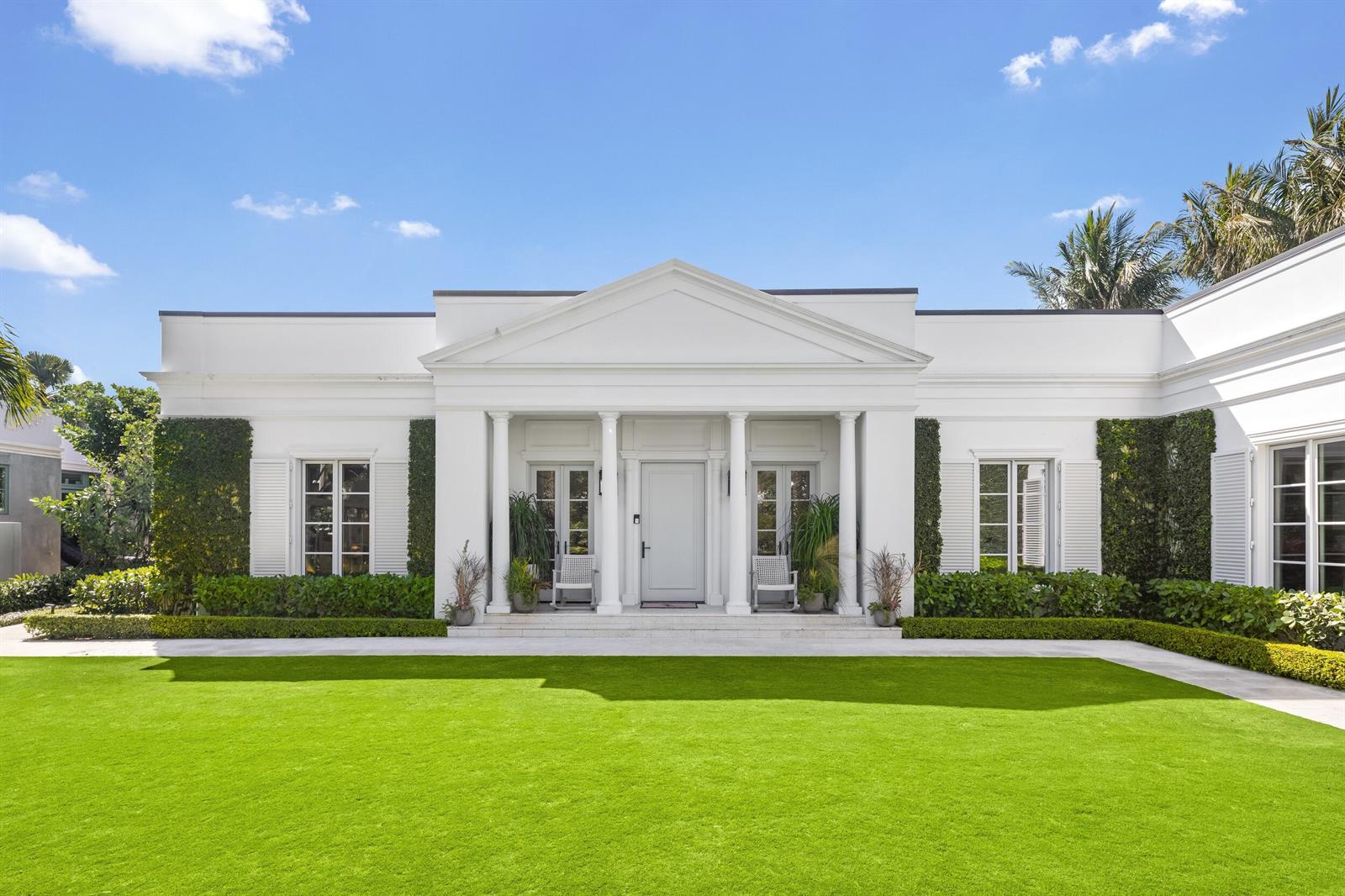 A white, single-story neoclassical house features a columned portico and a large, manicured green lawn — 208 Sandpiper Drive, Palm Beach FL 33480, PALM BEACH, FL