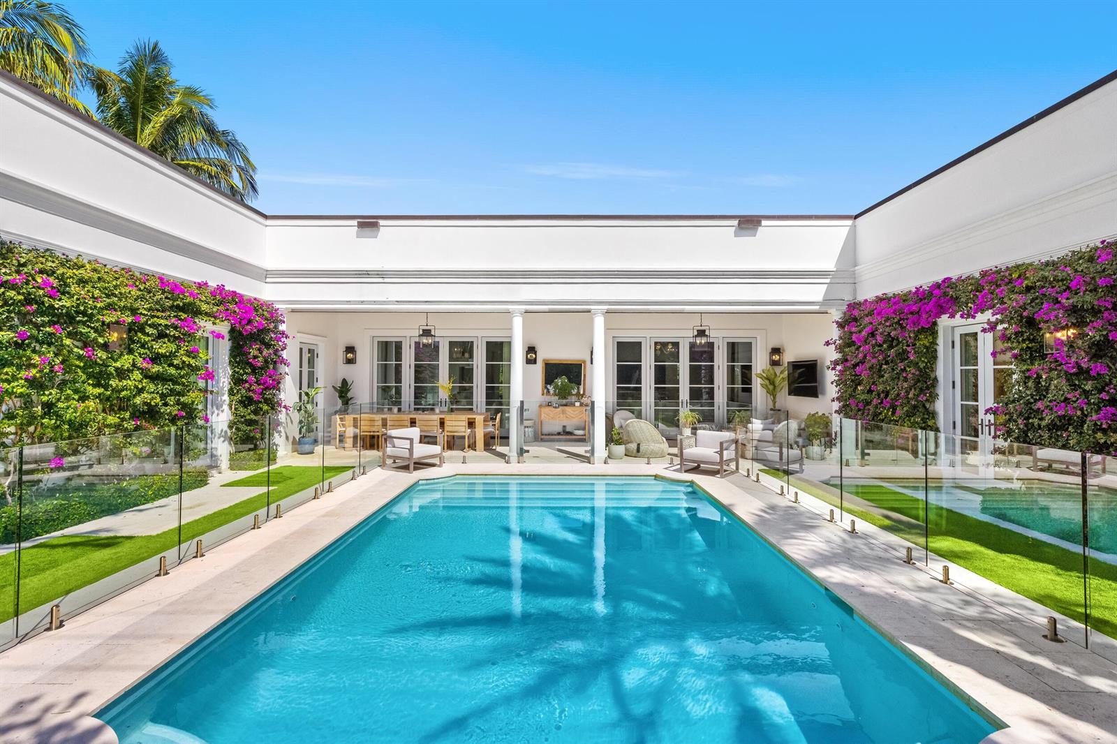 A rectangular swimming pool sits in the center of a courtyard surrounded by white walls — 208 Sandpiper Drive, Palm Beach FL 33480, PALM BEACH, FL