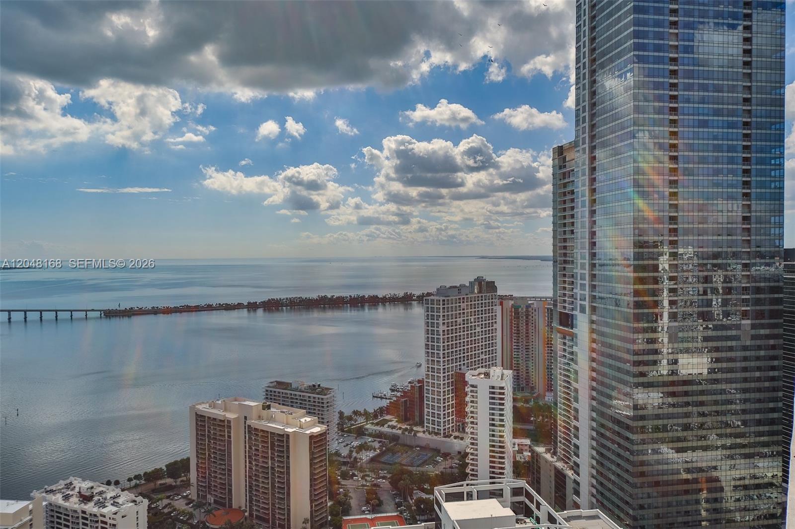 An elevated view of a coastal city skyline featuring high-rise buildings and a bridge — 1300 Brickell Bay Dr # 1206, Miami FL 33131, MIAMI, FL