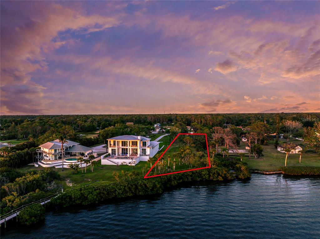 An aerial view shows a waterfront lot outlined in red next to a large house — BAYSHORE DRIVE, ENGLEWOOD, FL