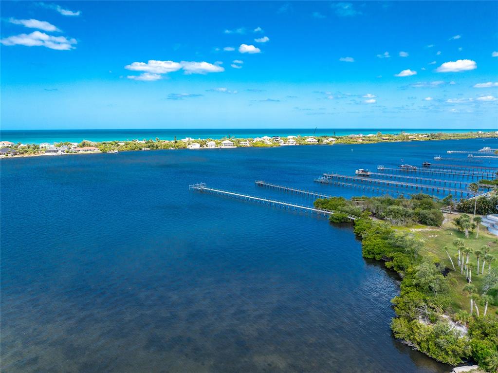An aerial view shows a long wooden dock extending into a blue bay near mangroves — BAYSHORE DRIVE, ENGLEWOOD, FL