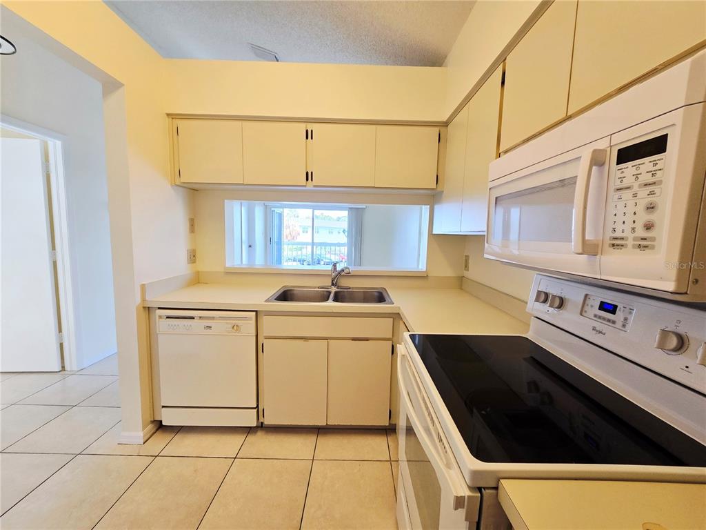 An open-concept living area features tile flooring, a vaulted ceiling, and a ceiling fan — 6802 STONES THROW CIRCLE N UNIT 14206, ST PETERSBURG, FL