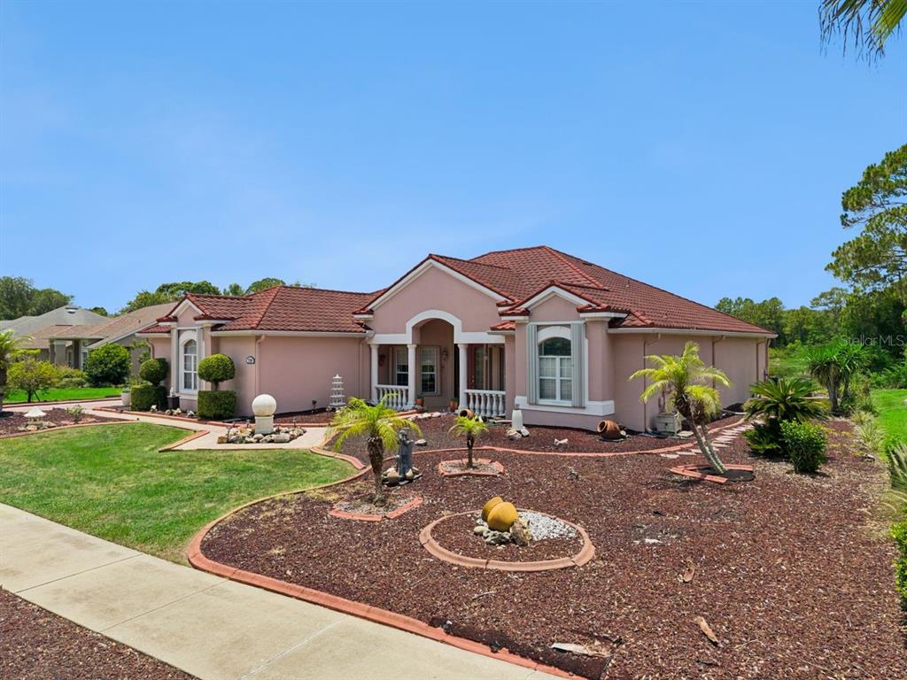 A single-story pink house with a red tile roof and a landscaped rock yard — 736 TIMACUAN BOULEVARD, LAKE MARY, FL