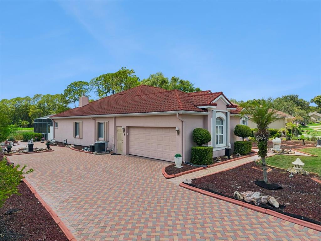 A single-story house with a red tile roof, pink stucco walls, and a brick driveway — 736 TIMACUAN BOULEVARD, LAKE MARY, FL
