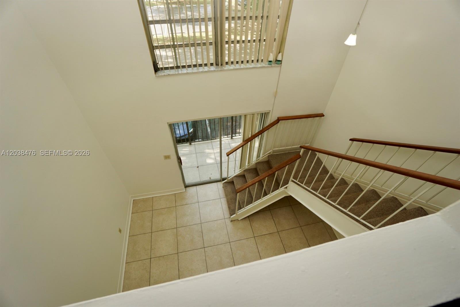 A high-angle view shows a tiled living area with a staircase and sliding glass doors — 8500 SW 109th Ave # 225, Miami FL 33173, MIAMI, FL