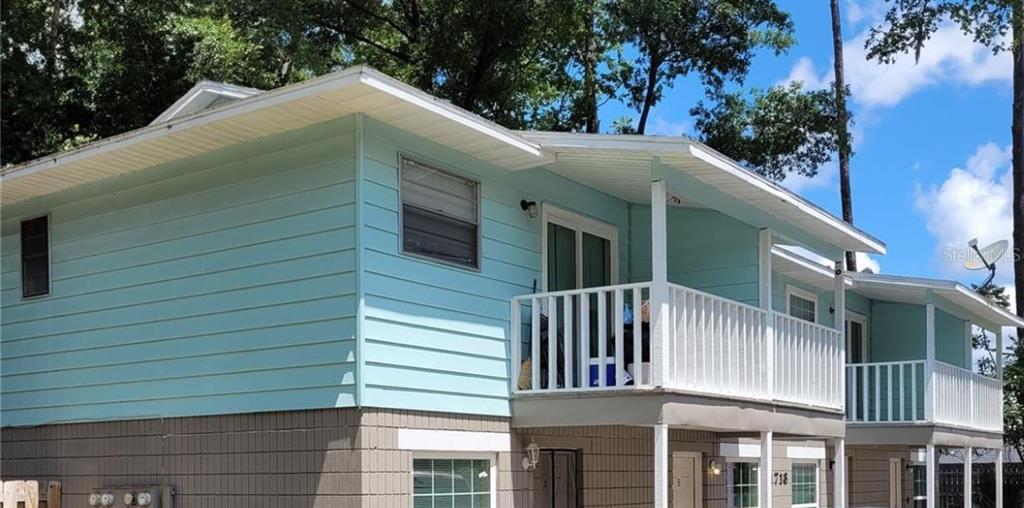A two-story building with light blue horizontal siding and a white balcony railing — 1718 SW 69 TERRACE, GAINESVILLE, FL