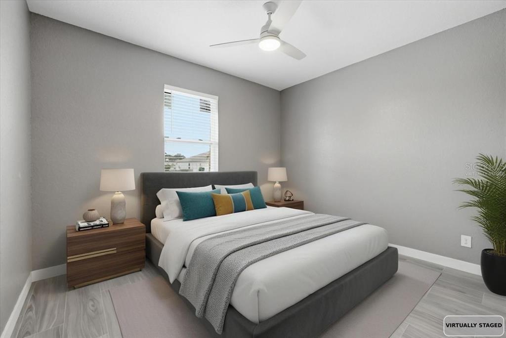A virtually staged bedroom features a gray upholstered bed, two nightstands, and a ceiling fan — 2683 HOPWOOD ROAD, NORTH PORT, FL