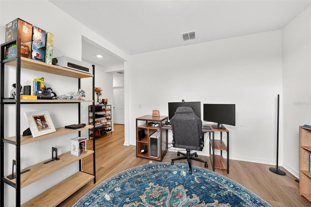 A home office features a desk with two monitors, a gaming chair, and open shelving — 2514 MOOSE TRAIL PLACE, DAVENPORT, FL