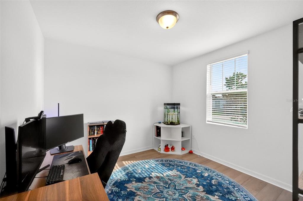 A home office features a desk, computer, corner shelf with an aquarium, and a circular rug — 2514 MOOSE TRAIL PLACE, DAVENPORT, FL