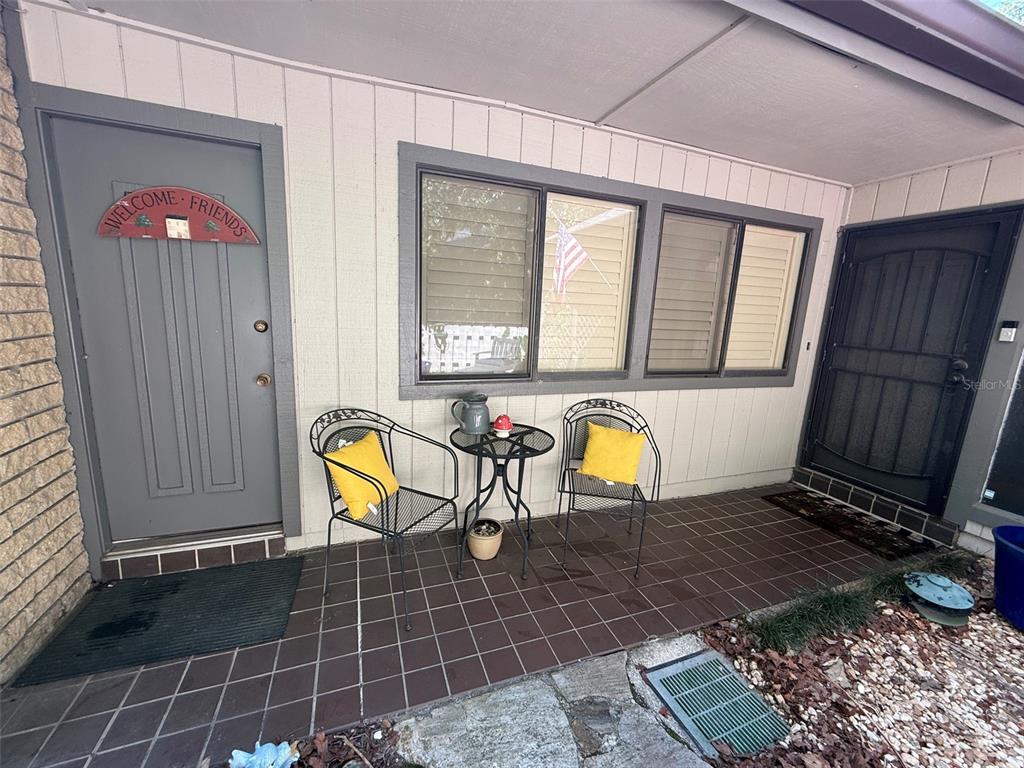A stone patio with outdoor furniture, a gravel area, and a brick exterior wall — 1629 NW 19TH CIRCLE, GAINESVILLE, FL