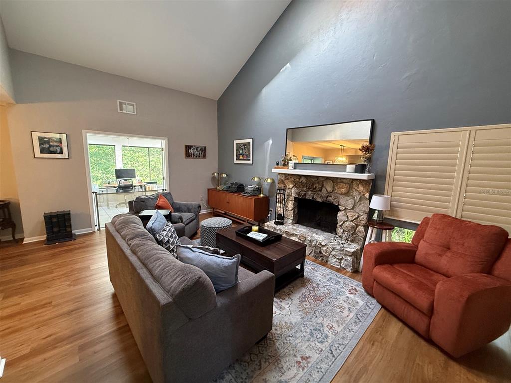 A small patio features gravel ground, two chairs, a fire pit, and a white fence — 1629 NW 19TH CIRCLE, GAINESVILLE, FL