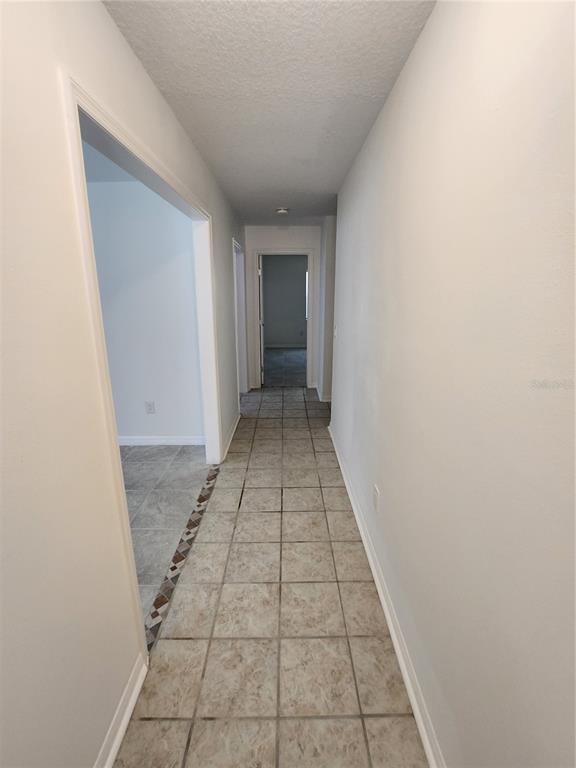 A tiled hallway leads to a doorway at the end of the corridor — 9 TEAK WAY DRIVE, OCALA, FL
