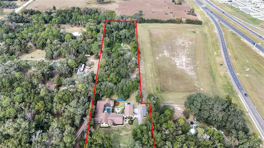 An aerial view shows a house with a pool surrounded by trees and open land — 3525 W KELLY PARK ROAD, APOPKA, FL