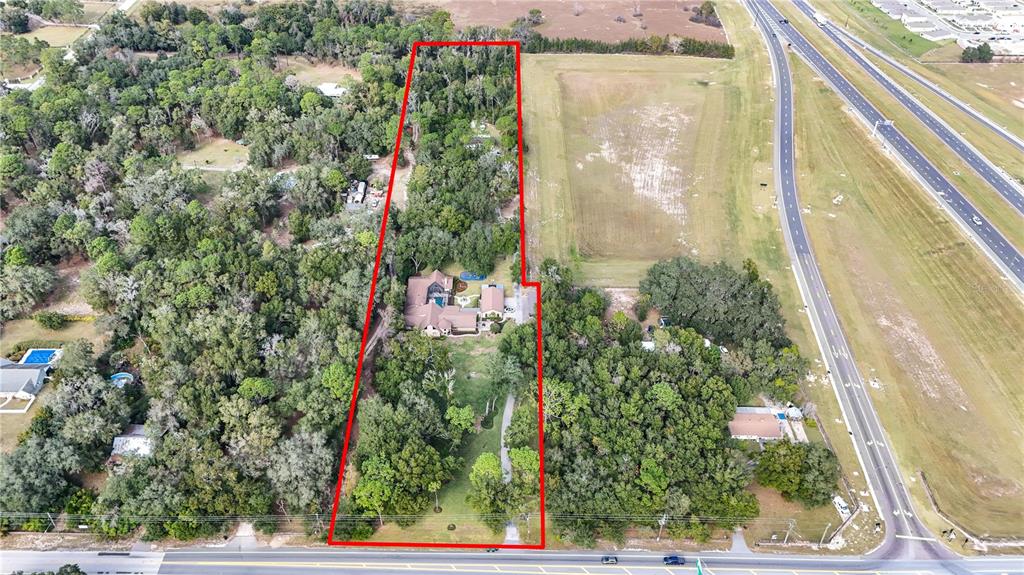 An aerial view shows a house with a pool on a large, wooded lot — 3525 W KELLY PARK ROAD, APOPKA, FL