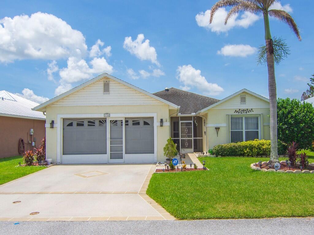 A single-story house with a garage, a screened entryway, and a palm tree in front — 6704 Picante Circle, Fort Pierce FL 34951, FORT PIERCE, FL