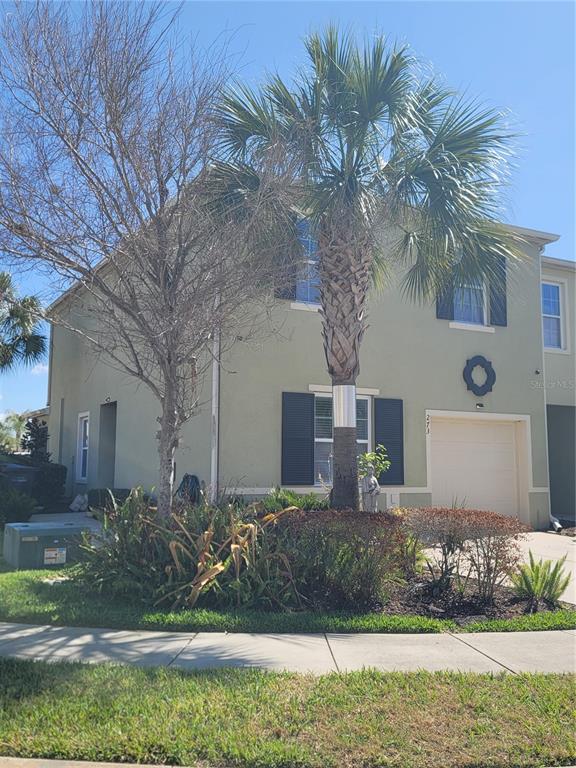 A two-story light green house with a palm tree and landscaping in the front yard — 273 ARBOR LAKES DRIVE, DAVENPORT, FL