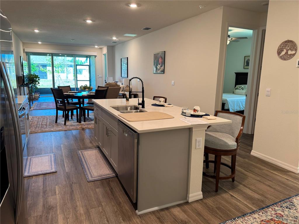 A kitchen island with a sink and faucet sits in an open-concept home interior — 2615 KINSALE LANE, ORMOND BEACH, FL