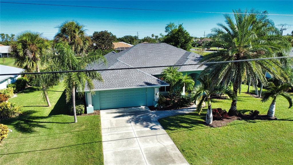 An aerial view of a light blue house with a gray roof and palm trees — 525 ROTONDA CIRCLE, ROTONDA WEST, FL
