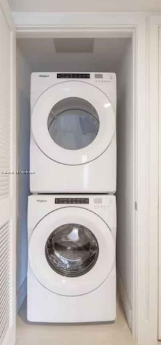 A stacked white Whirlpool washer and dryer unit is installed inside a small closet — 601 NE 1st Ave # 1720, Miami FL 33132, MIAMI, FL