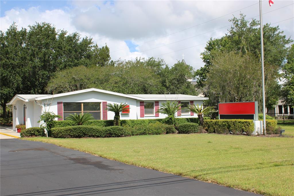 A single-story building with a white exterior, red shutters, and a prominent sign out front — 3150 N MCMULLEN BOOTH ROAD, CLEARWATER, FL
