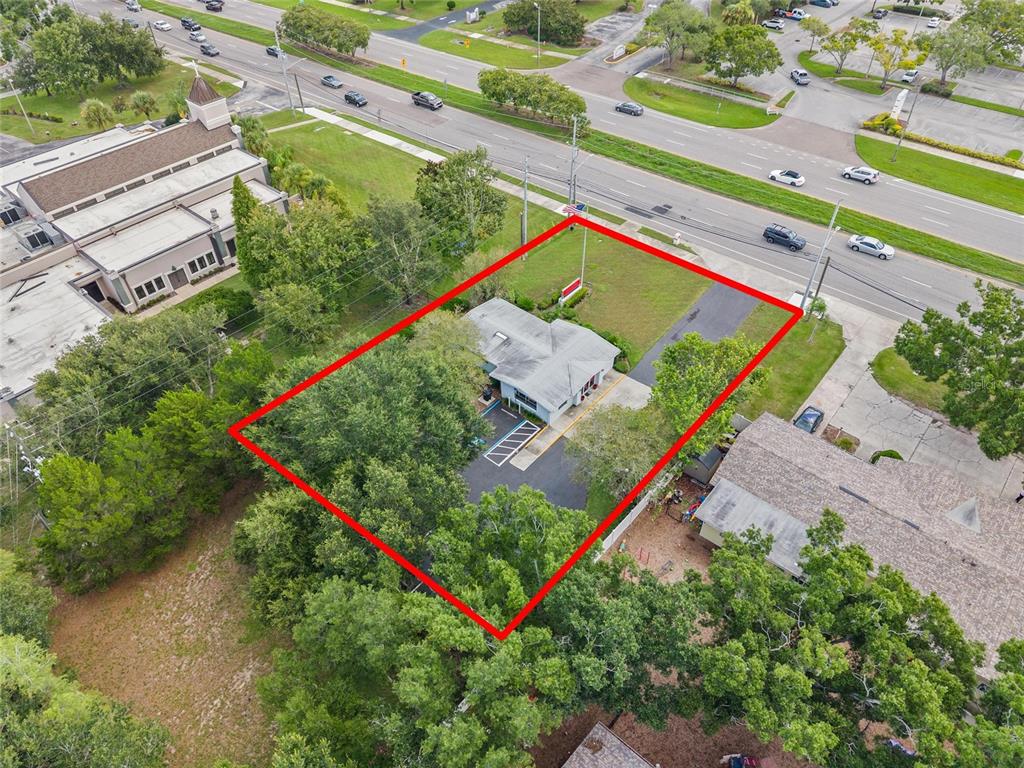An aerial view shows a commercial building on a lot outlined in red — 3150 N MCMULLEN BOOTH ROAD, CLEARWATER, FL
