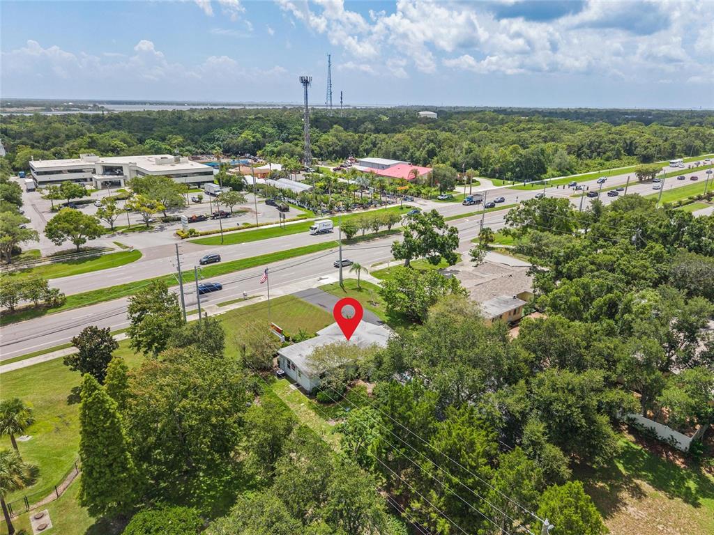 An aerial view shows a single-story house with a red location pin near a road — 3150 N MCMULLEN BOOTH ROAD, CLEARWATER, FL