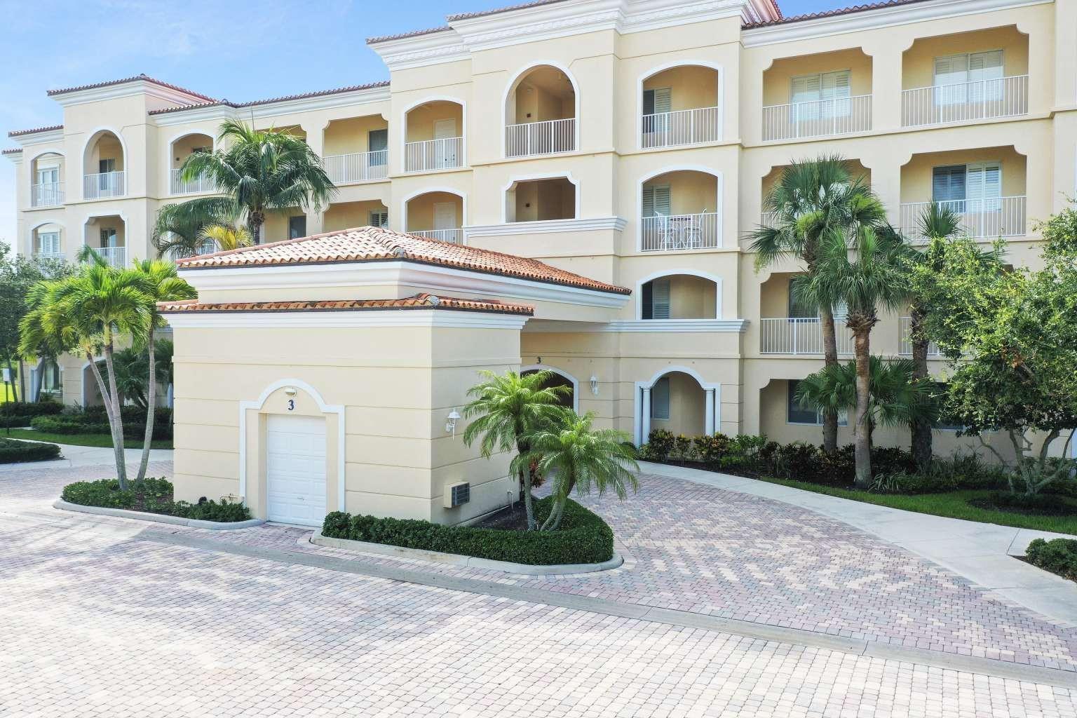 A multi-story beige stucco apartment building features arched balconies and a paved circular driveway — 3 Harbour Isle Drive # 302, Fort Pierce FL 34949, FORT PIERCE, FL
