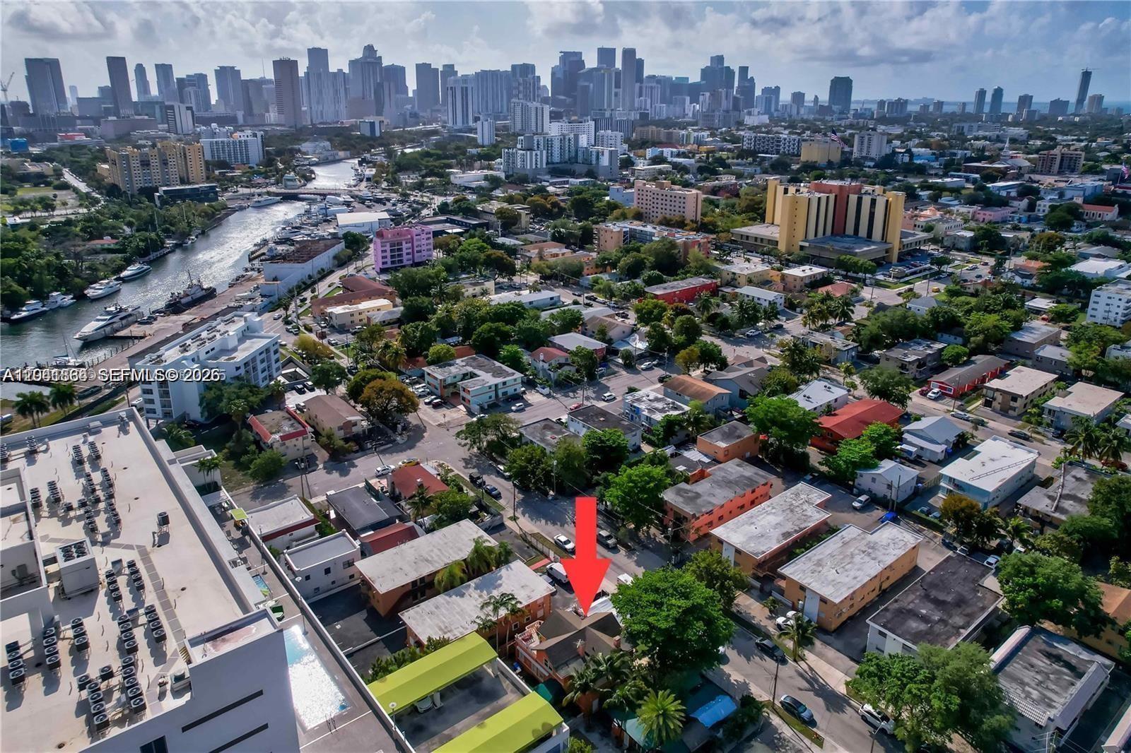 An aerial view shows a residential neighborhood with a red arrow pointing to a house — 1033 NW 6th St Unit 1, Miami FL 33136, MIAMI, FL