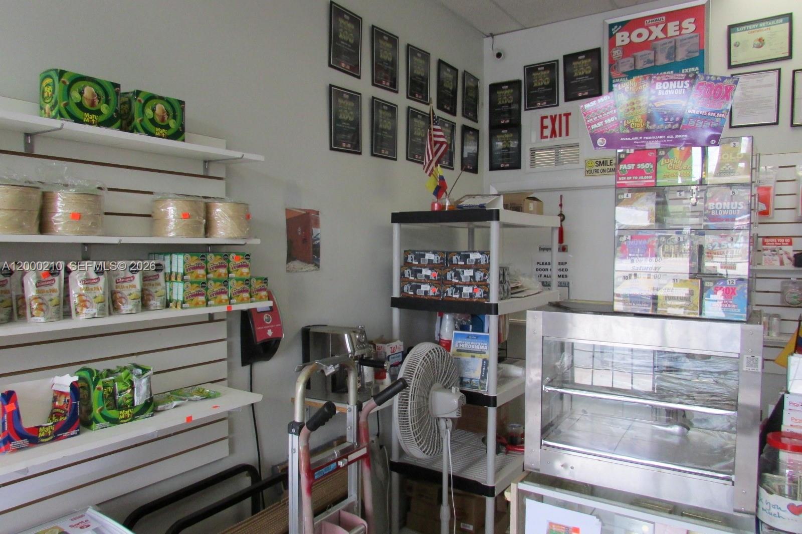 A small retail space features shelves stocked with food products, a lottery display, and equipment — 4330 SW 8th St, Coral Gables FL 33134, CORAL GABLES, FL