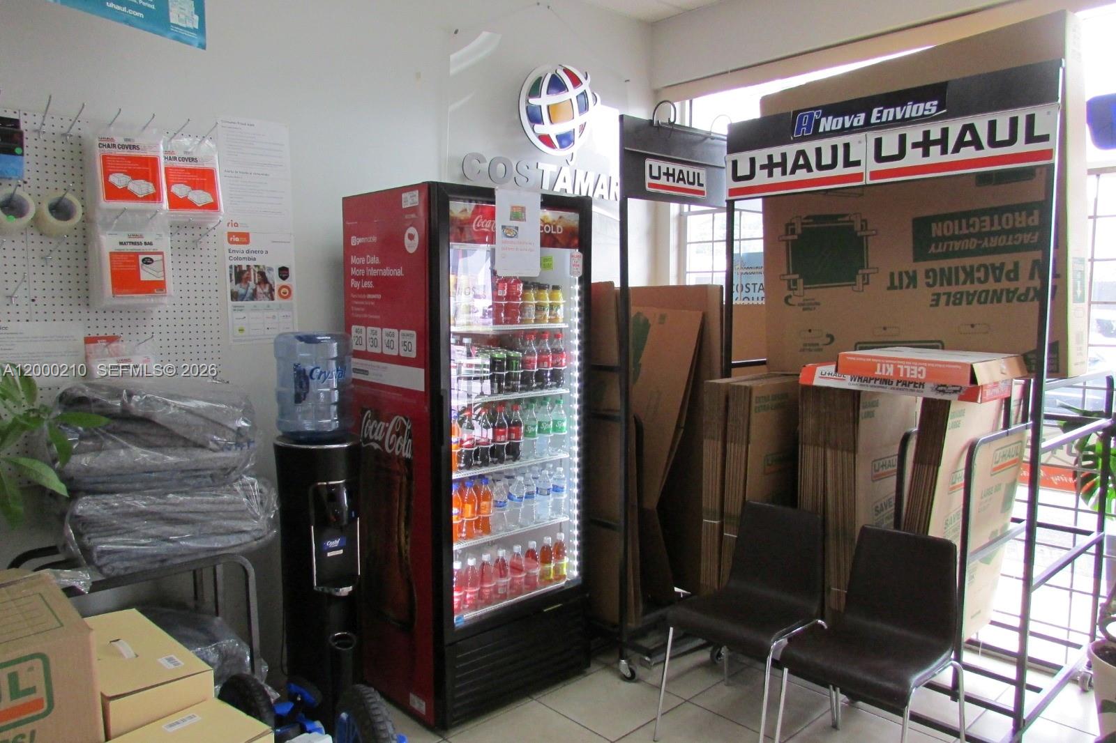 A retail space features a U-Haul display, a Coca-Cola refrigerator, and stacked cardboard moving boxes — 4330 SW 8th St, Coral Gables FL 33134, CORAL GABLES, FL