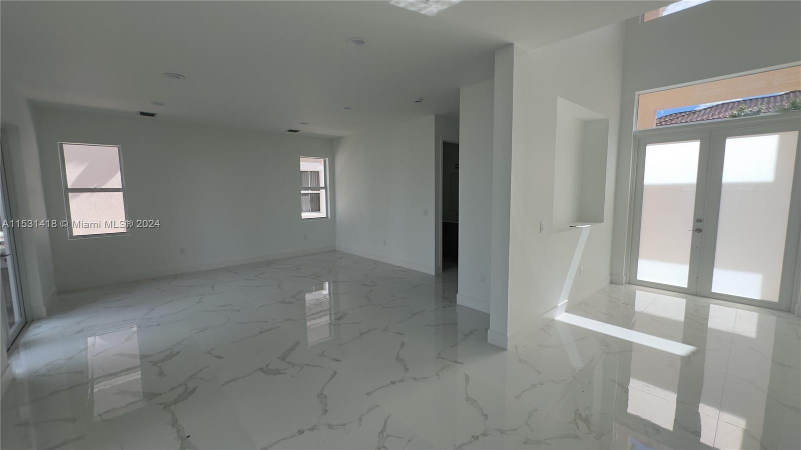 An empty room features white walls, recessed lighting, and polished white marble-look tile flooring — 3523 Forest View Cir, Dania Beach FL 33312, DANIA BEACH, FL
