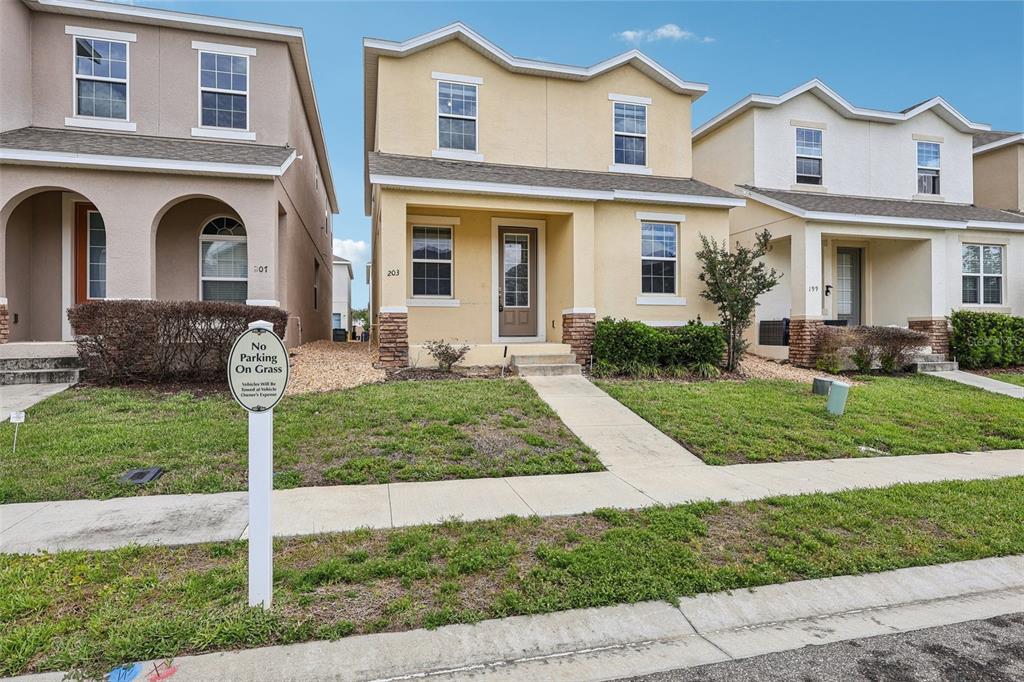 A yellow two-story house with a front porch and a no parking sign on grass — 203 BOYDFIELD LANE, DAVENPORT, FL