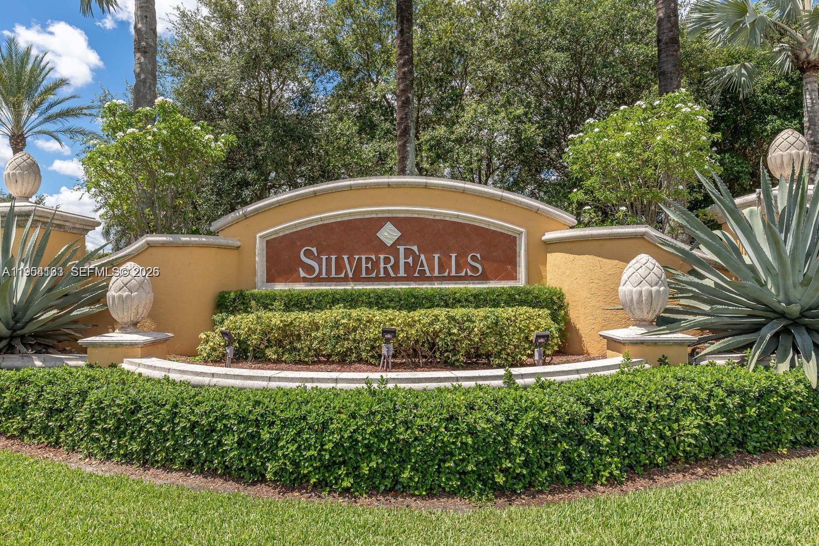 A stone monument sign for Silverfalls stands in a landscaped garden with palm trees — 13216 SW 44th St # 11204, Miramar FL 33027, MIRAMAR, FL