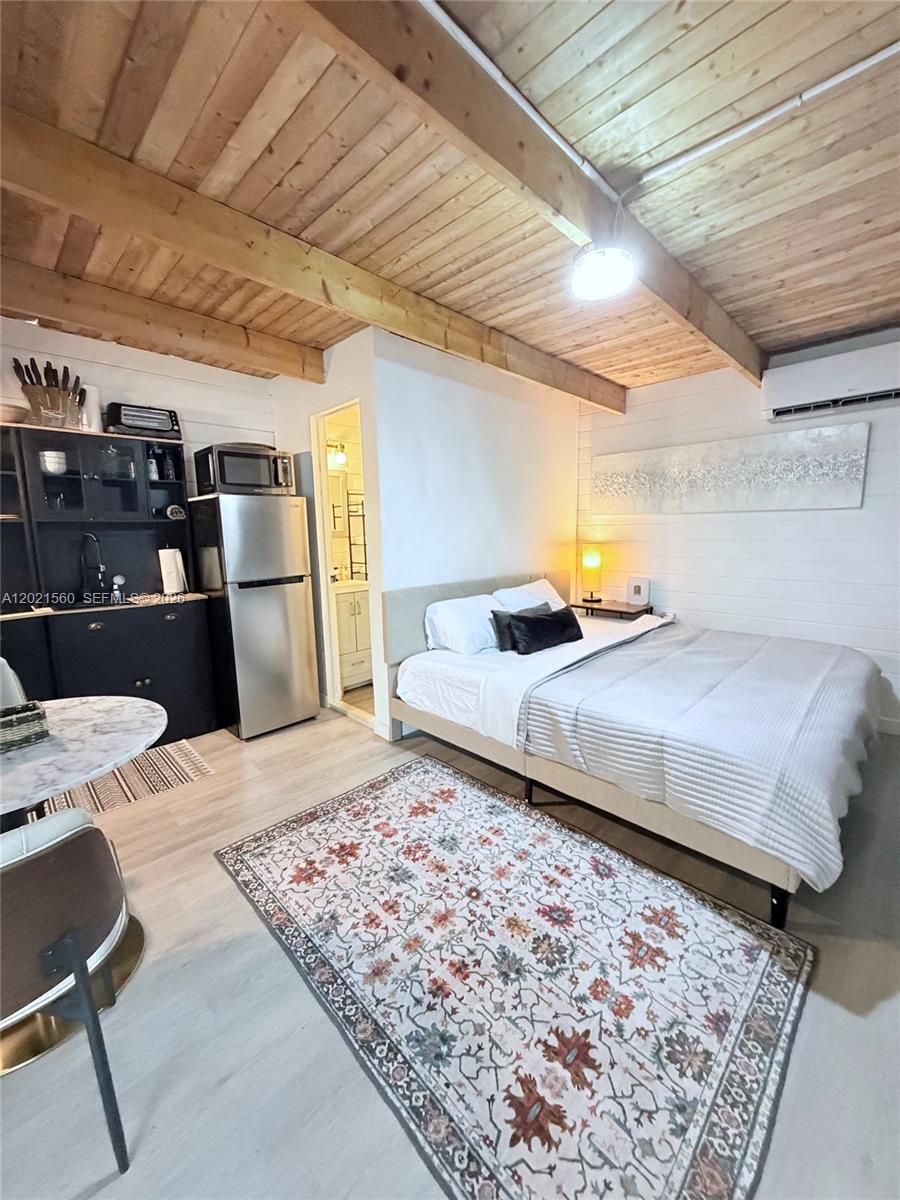 A studio apartment features a kitchenette, a bed, and a wooden beamed ceiling — TAVERNIER, FL