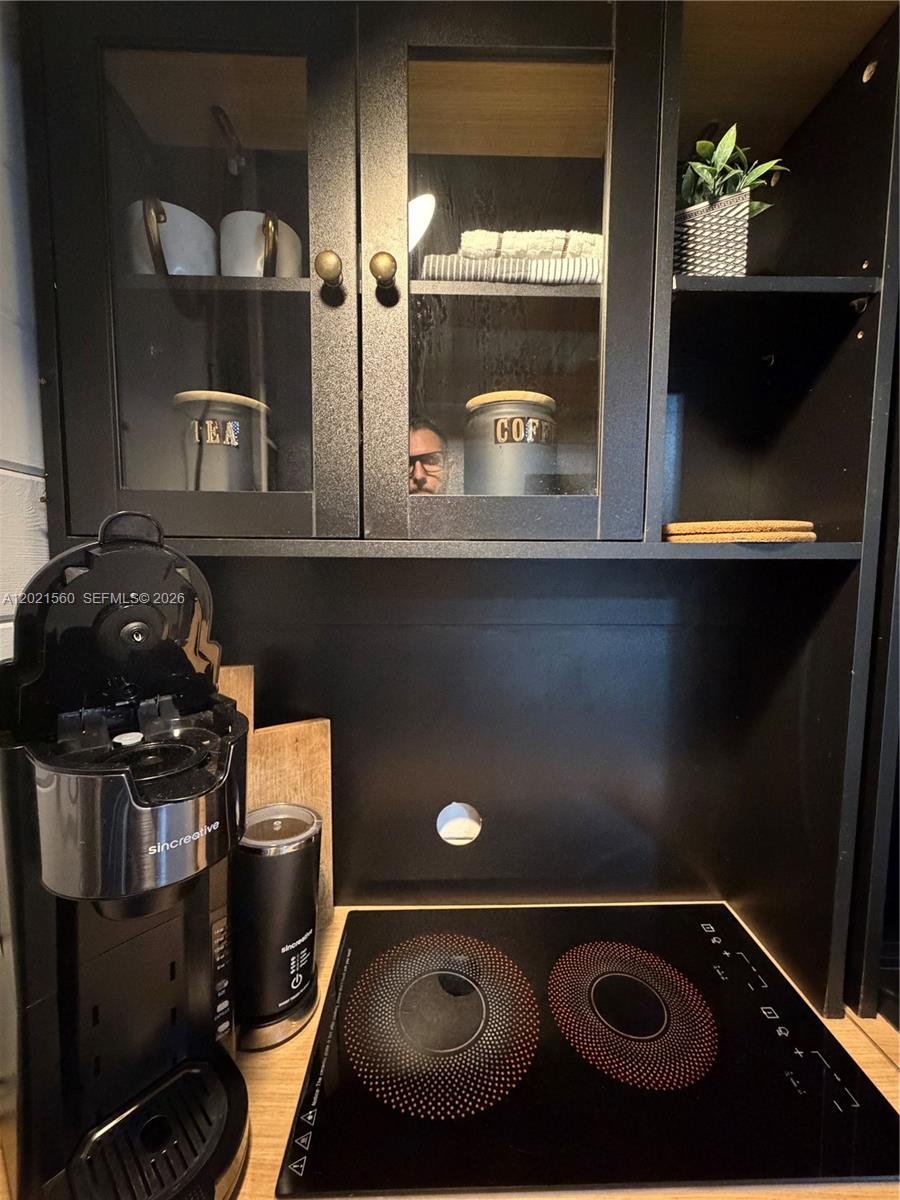 A kitchen coffee station features black cabinets, a dual-burner induction cooktop, and a coffee maker — TAVERNIER, FL
