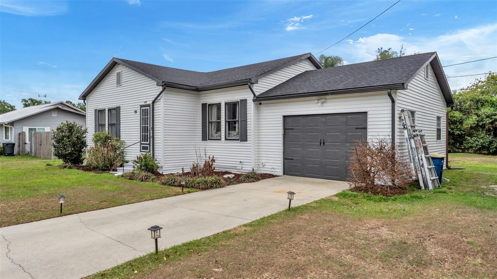 A single-story house with white siding, a dark roof, and an attached garage — 495 W PLUMOSA STREET, BARTOW, FL