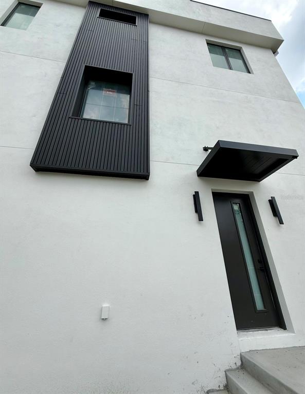 An exterior view shows two modern white townhomes facing each other across an unpaved driveway — 310 W COLUMBUS DRIVE UNIT 7, TAMPA, FL