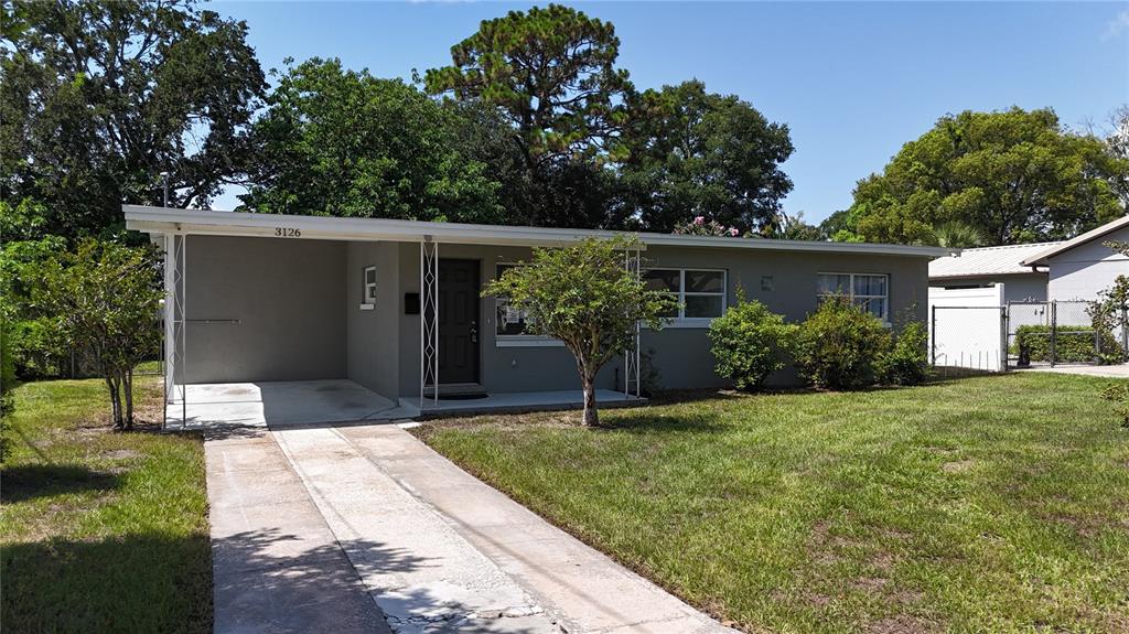 A single-story house with a flat roof, a carport, and a concrete driveway — 3126 KELVINGTON DRIVE, ORLANDO, FL