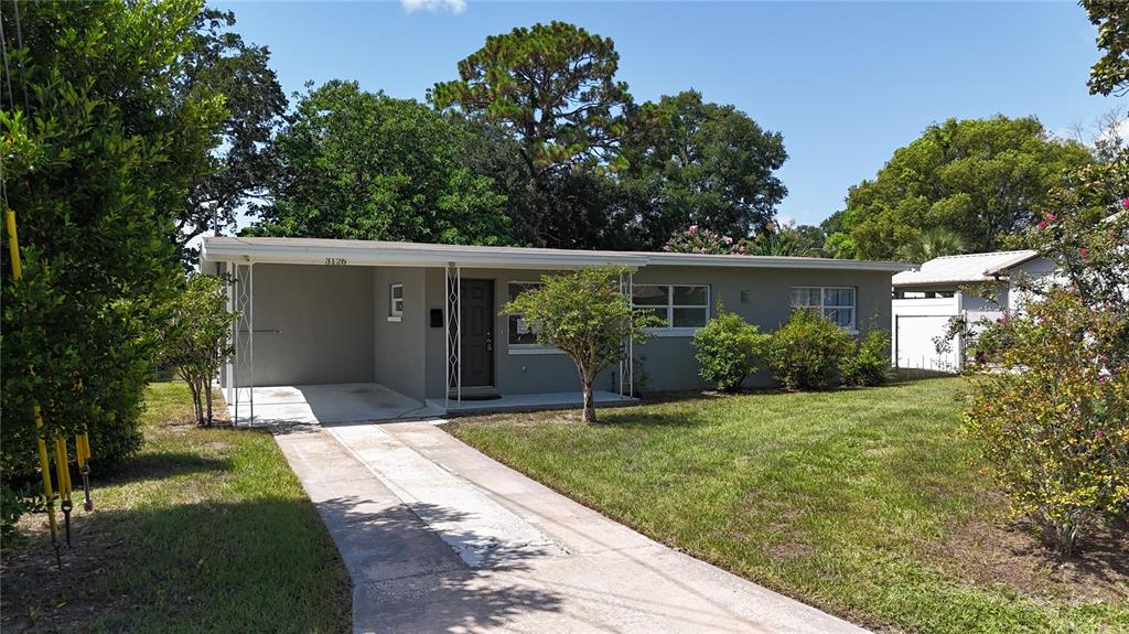 A single-story house with a flat roof, a carport, and a concrete driveway — 3126 KELVINGTON DRIVE, ORLANDO, FL