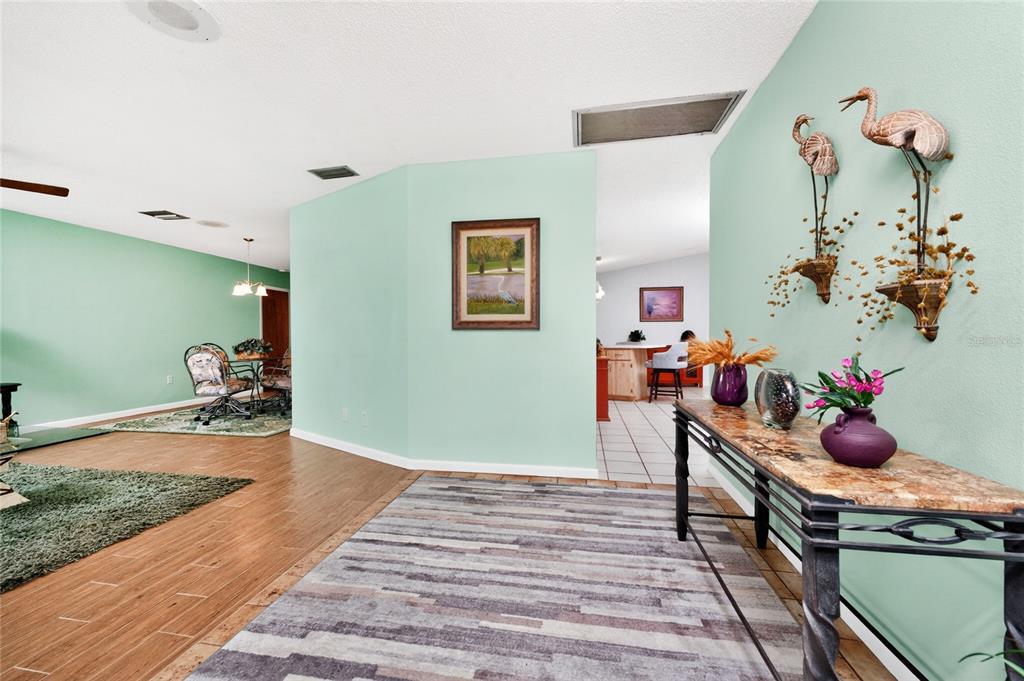 An entryway with wood-look tile flooring leads into a living area with light green walls — 23278 MCNAMEE AVENUE, PORT CHARLOTTE, FL