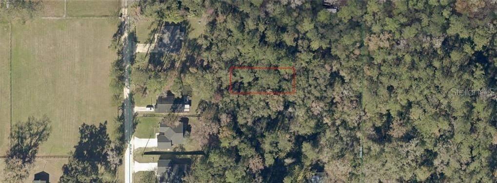 An aerial view shows a rectangular plot of land outlined in red within a wooded area — 3637-004-018 SE 22ND COURT, OCALA, FL